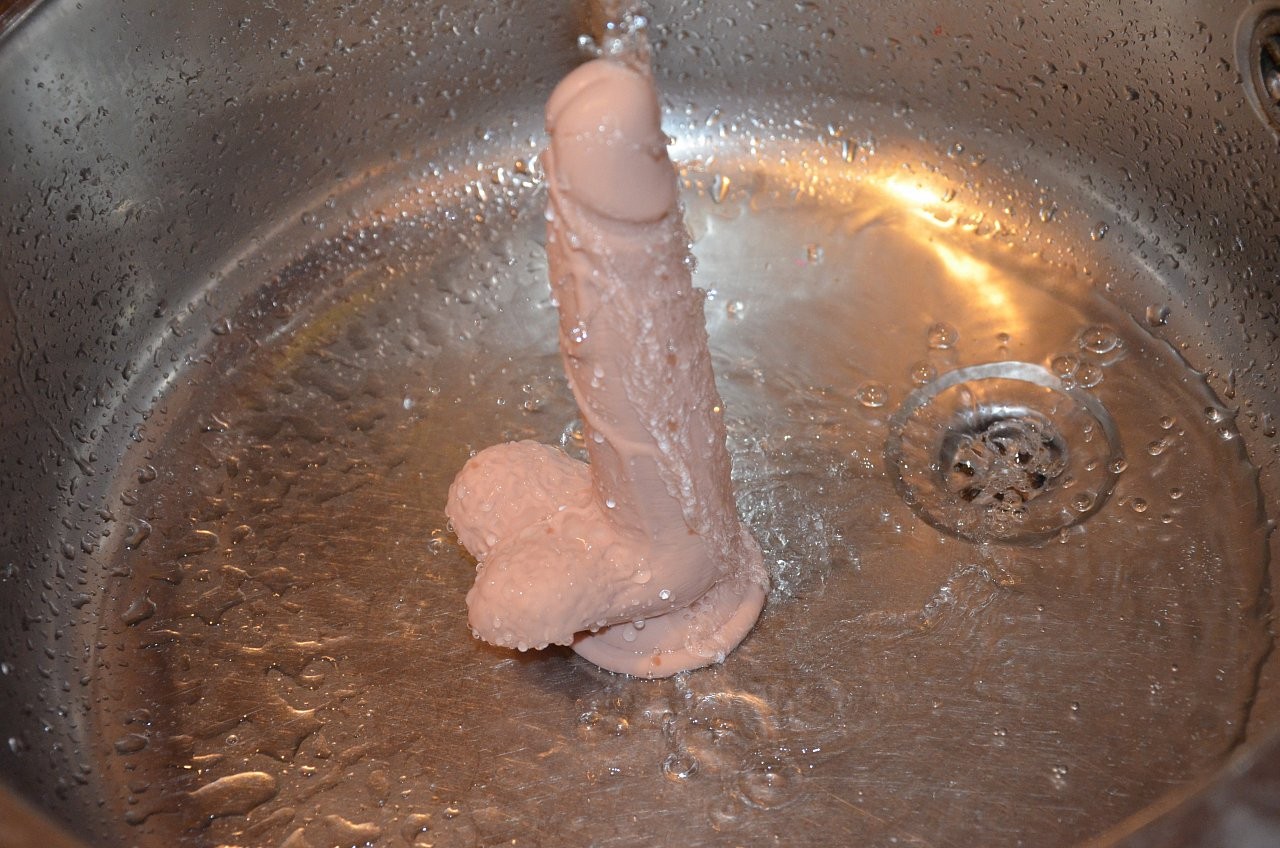 Dildo s prísavkou a semenníkmi Silicone (18 cm), pod prúdom vody