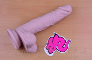 Dildo s prísavkou a semenníkmi Silicone (18 cm), leží na stole